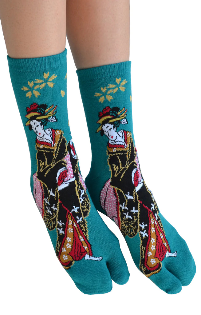 This is a photo of a woman's leg wearing the teal color of the product name KABUKI TABI TOE SOCKS of the brand name NINJA SOCKS