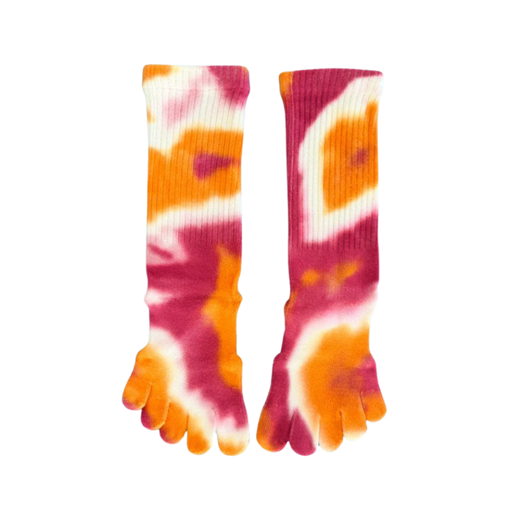 A person sitting with tie-dye five toe socks in yellow, blue, and gray colors, showing the five separate toe sections and the cushioned sole.