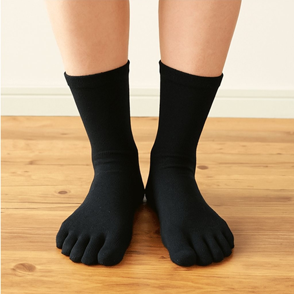 Black five-finger socks worn on a wooden floor