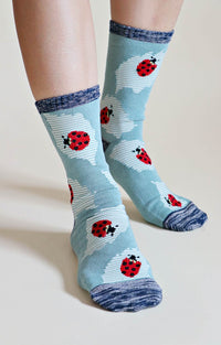 TABBISOCKS brand Replant Pairs Ladybug Organic Cotton Crew Socks in Dusty Mint color with a red ladybug pattern with grayish dark blue inserts at the mouth, toe and heel.