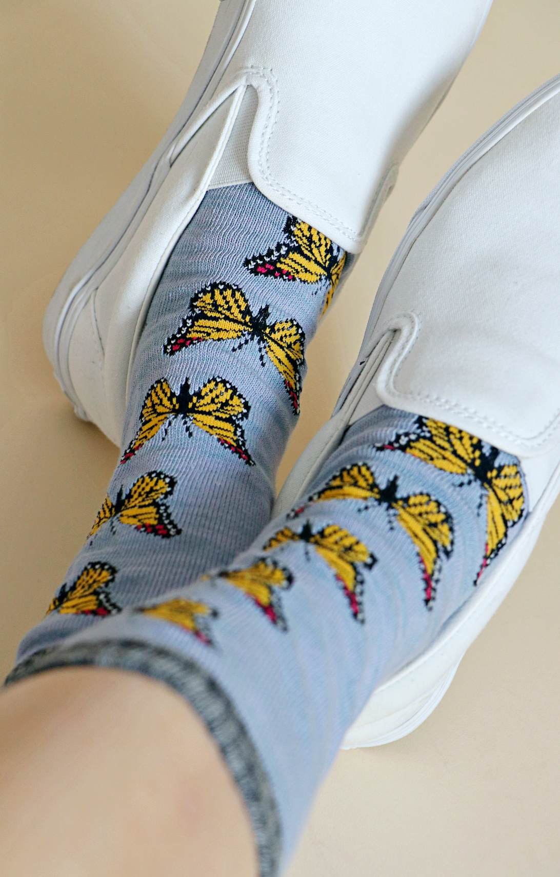 TABBISOCKS brand Replant Pairs "Monarch Butterfly" Organic Cotton Crew Socks with a butterfly pattern in Light Blue color with grayish green inserts at the mouth, toe and heel. The socks have a butterfly pattern on the mouth, toe, and heel in grayish green.