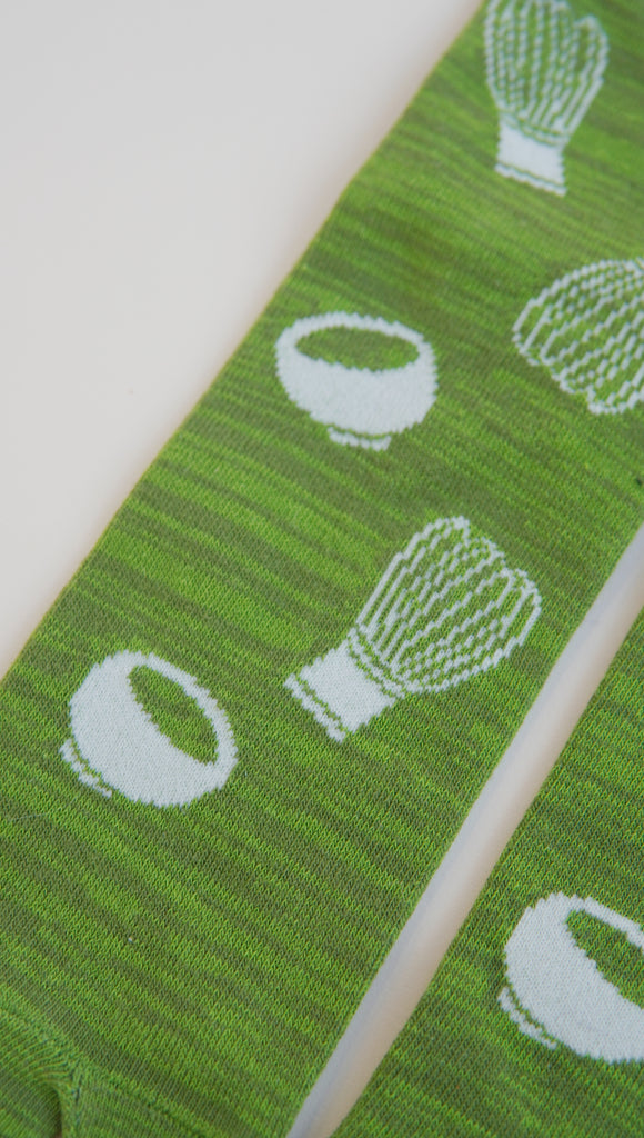 Green sock with white patterns on a white background