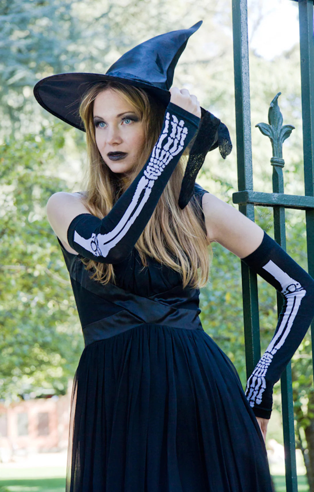 Woman dressed as a witch wearing Tabbisocks Skeleton Arm Warmers Halloween