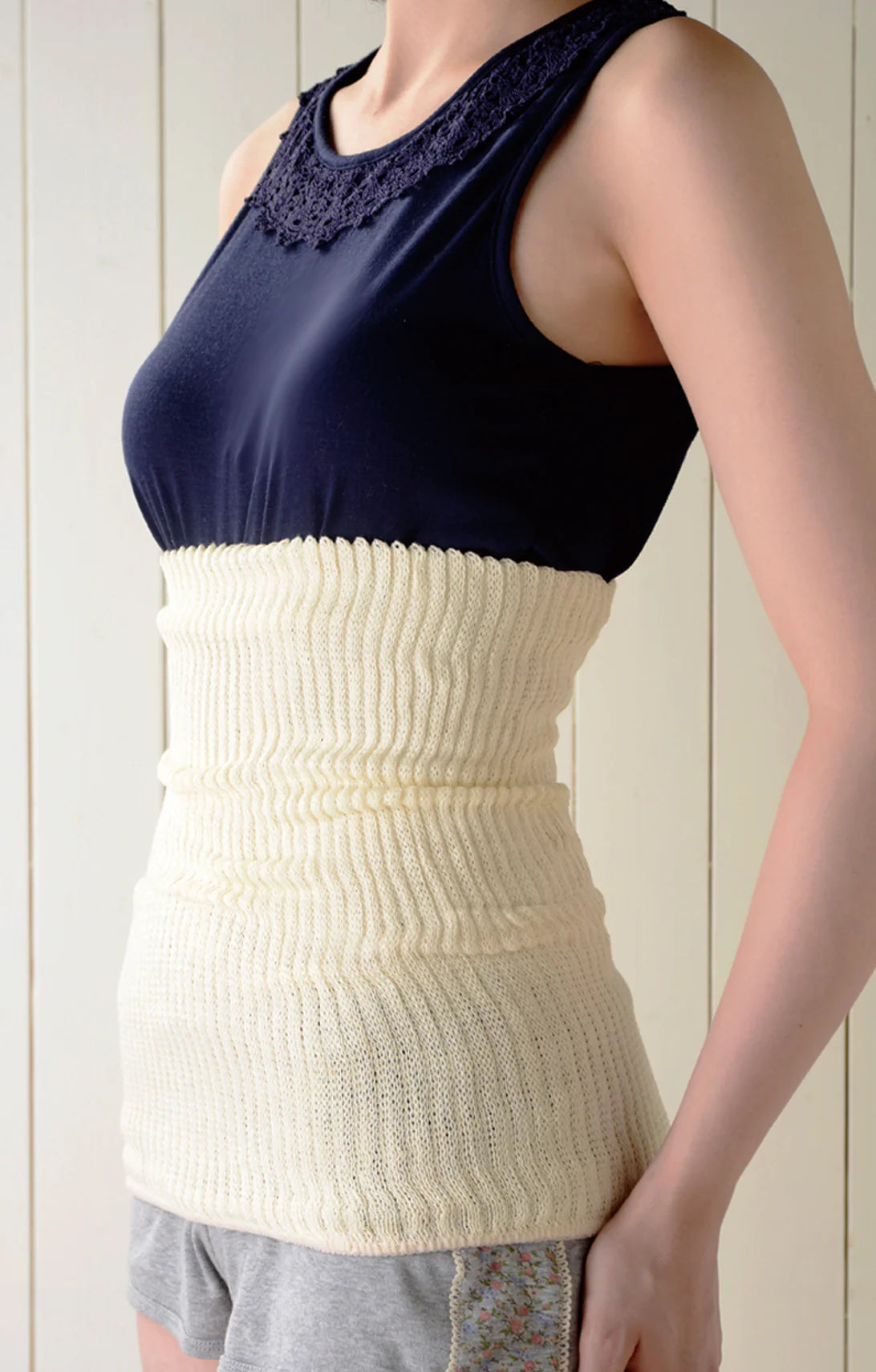 Upper body of woman in navy blue tank top wearing Silkdays Silk Lined Cotton Belly Band (Haramaki) in Light Beige