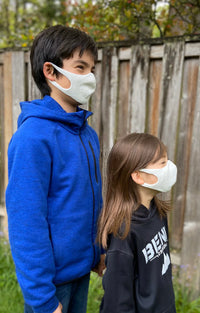 Siblings wearing Tabbisocks Wellness' Organic Cotton Face Mask For Kid-Youth in a dark ivory color