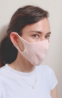 Woman in white T-shirt wearing the pink color of The Japanese Seamless Comfort Face Mask With Filter Pocket from Tabbisocks Wellness