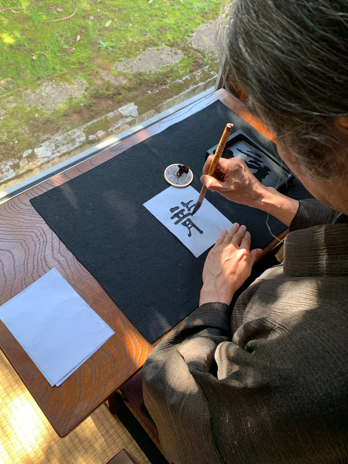 Female calligrapher designing the dragon kanji on Kihachiro Sho's Dragon Lucky Kanji Calligraphy Crew Socks