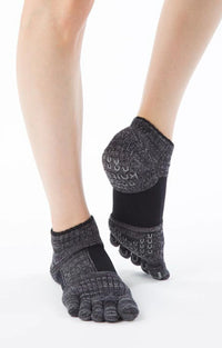 Legs wearing Socks with the product name Arch Support Grip Toe Socks With Power Pads by Knitido plus in Black color.