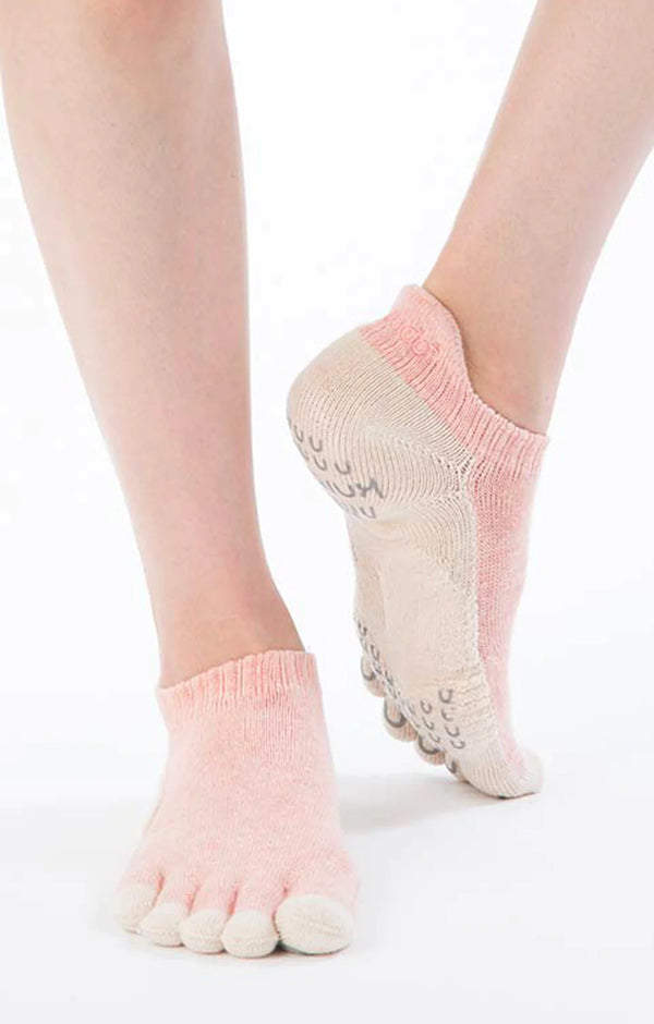 Woman's foot wearing PINK color of Knitido plus' Botanical Dyed Pilates Grip Toe Socks With *Power Pads*.