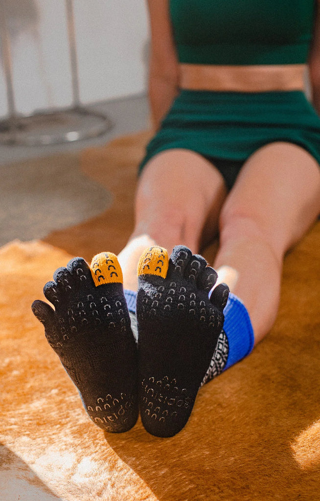 Woman in green sportswear wearing Organic Cotton Diamond Midcalf Toe Grip Socks With *Power Pads* in Black from the brand Knitido plus