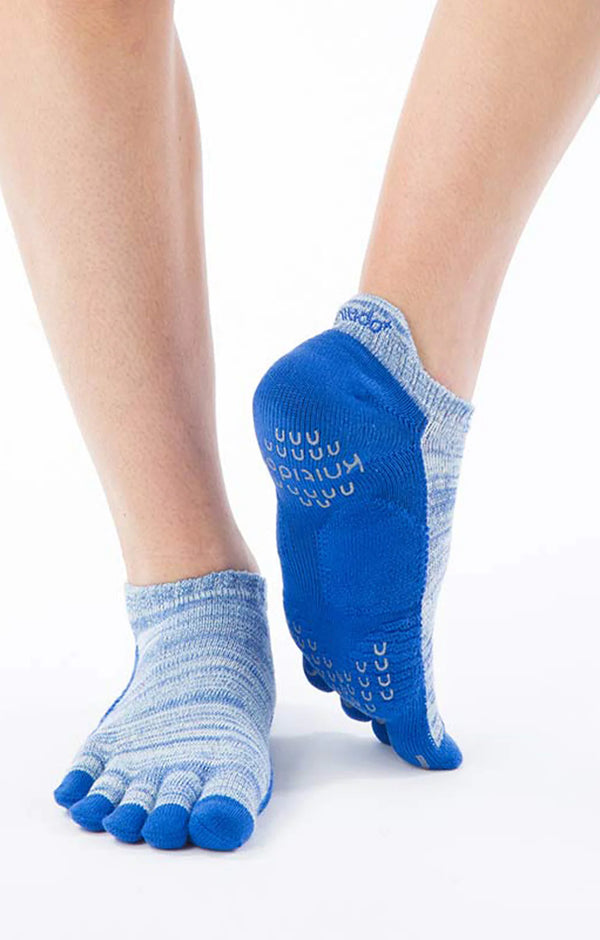 This is a front view of a leg wearing the brand name Knitido+ product HEATHER FOOTIE TOE GRIP SOCKS WITH *POWER PADS* BLUE color