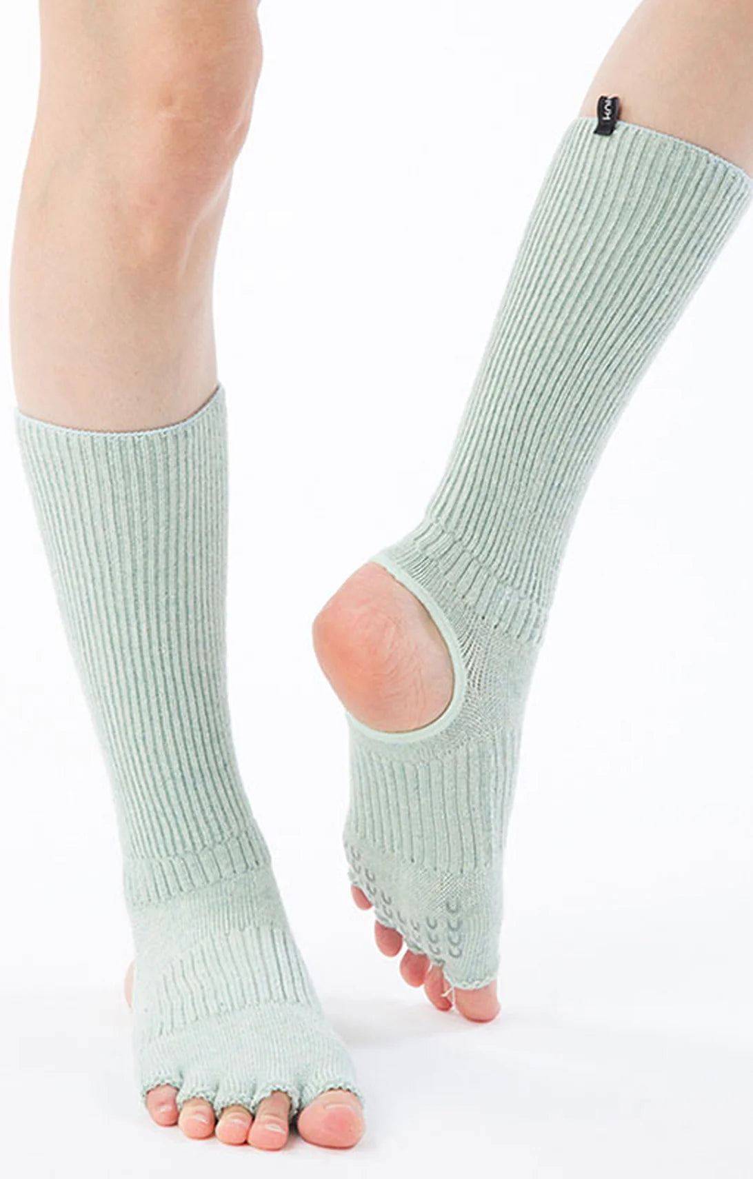 Front view of a woman's leg wearing Knitido plus brand Organic Cotton Botanical Dyed Open Toe and Heel Grip Socks in Mint color