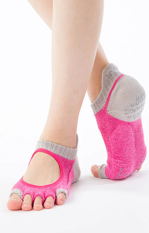 This is a photo of a woman's leg wearing the brand name Knitido+ product TWO COLORS OPEN GRIP TOE FOOTIE *POWER PADS* SOCKS in the color Pink