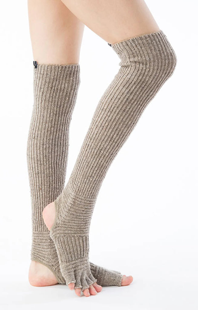 Side view of a woman's leg wearing a pair of Knitido plus brand Wool Blend Confetti Ribbed Open Toe and Heel Socks in the color Ecru, which is an ivoryish color