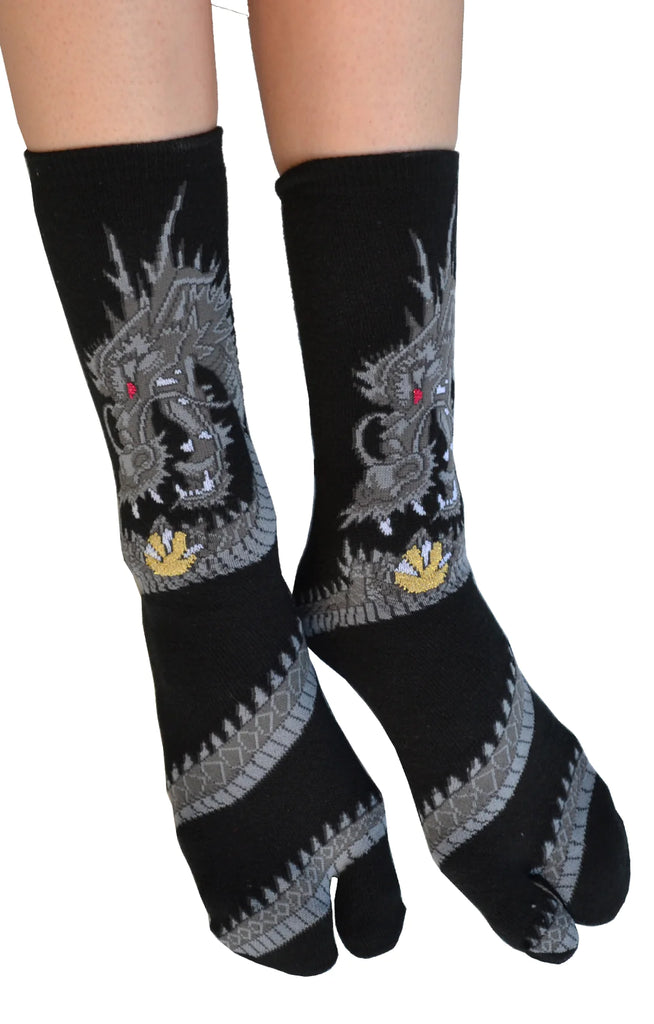 Photo of a woman's leg wearing the product name DRAGON TABI SOCKS Grey with dragon design of NINJA SOCKS