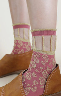 Socks with the trade name Golden Paisley Sheer Socks by Tabbisocks, on the feet of a woman wearing brown leather shoes wearing ROSE GOLD color