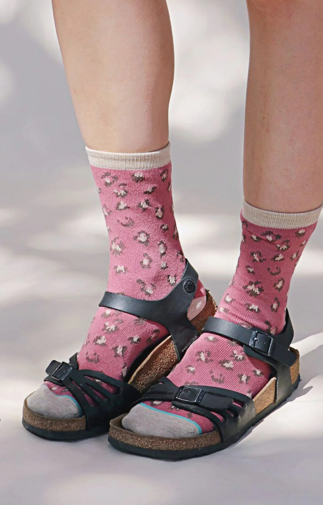 Legs in ROSE color Socks named Leopard Animal Organic Cotton Crew Socks by Tabbisocks and worn with black leather sandals by BIRKENSTOCK