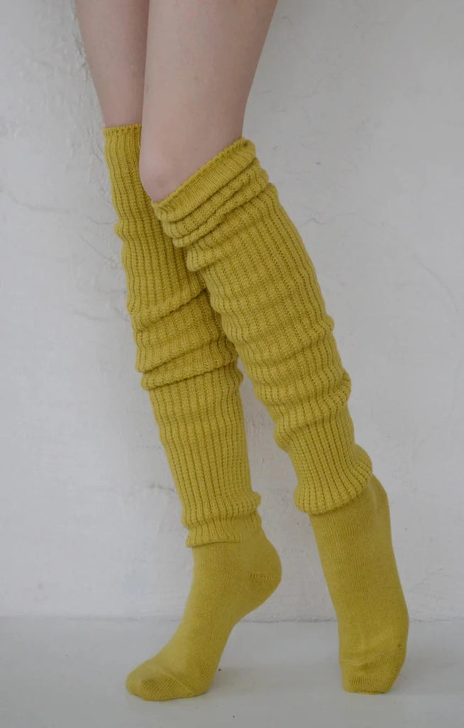 This is a photo of a woman's leg wearing Tabbisocks product name Scrunchy Over The Knee Lounge Wool Blend Socks Bitter Yellow