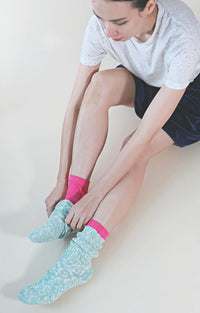Woman wearing Tabbisocks Washable 100%Silk Toe Liner Socks in Fuchsia pink with light blue socks