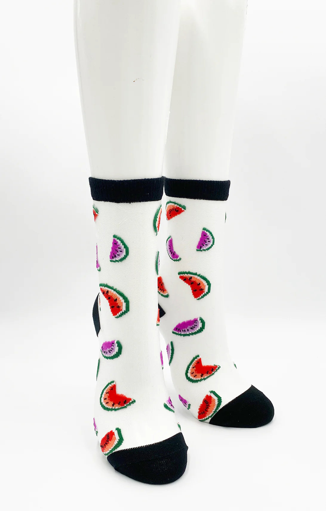 Legs wearing Tabbisocks Watermelon Sheer Socks, a pair of white socks with a cut watermelon pattern and black top and bottom