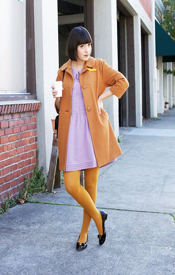 MUSTARD color of Tabbisocks' 23 Colors Opaque Zokki Tights trade name tights with a woman with black bobbed hair wearing a camel colored coat and black pumps