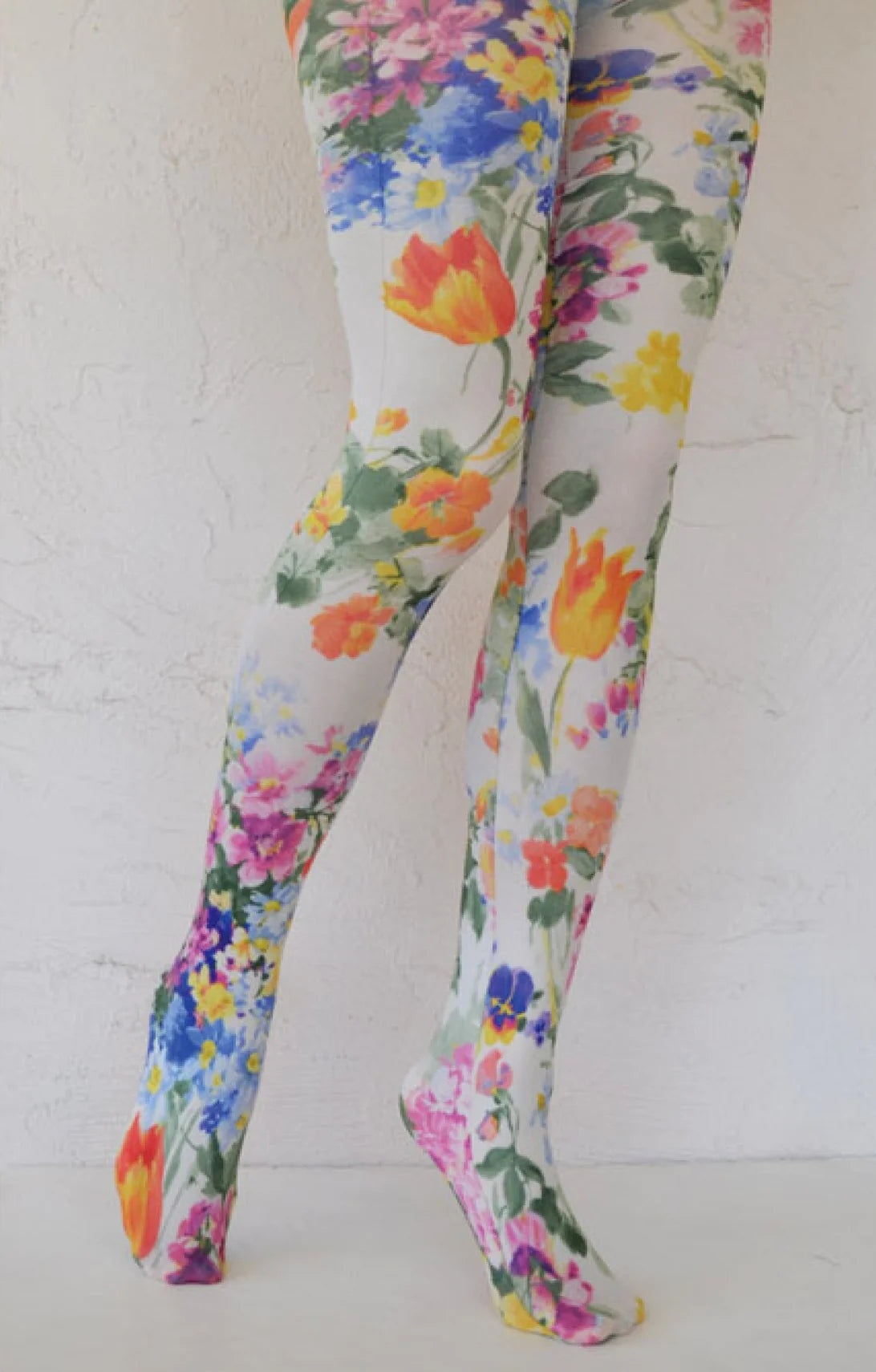 This is a photo of a woman's leg wearing Tabbisocks' product name Bright Tulip Printed Art Tights white