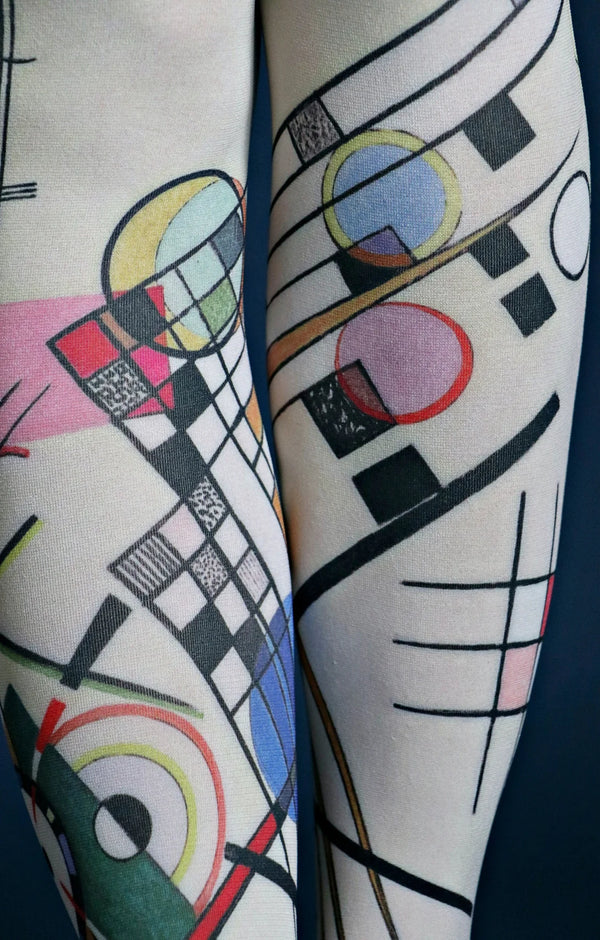 Tabbisocks Composition Viii By Wassily Kandinsky Printed Art Tights in navy blue, fabric is a light greenish color, geometric pattern with red, pink, light blue, green and other square and circle symbols, enlarged photo of calf area