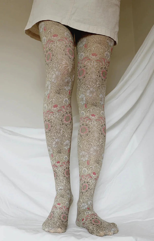 Lower half of a woman wearing an ivory colored skirt wearing tights called Corn Cockle By William Morris Printed Art Tights by Tabbisocks