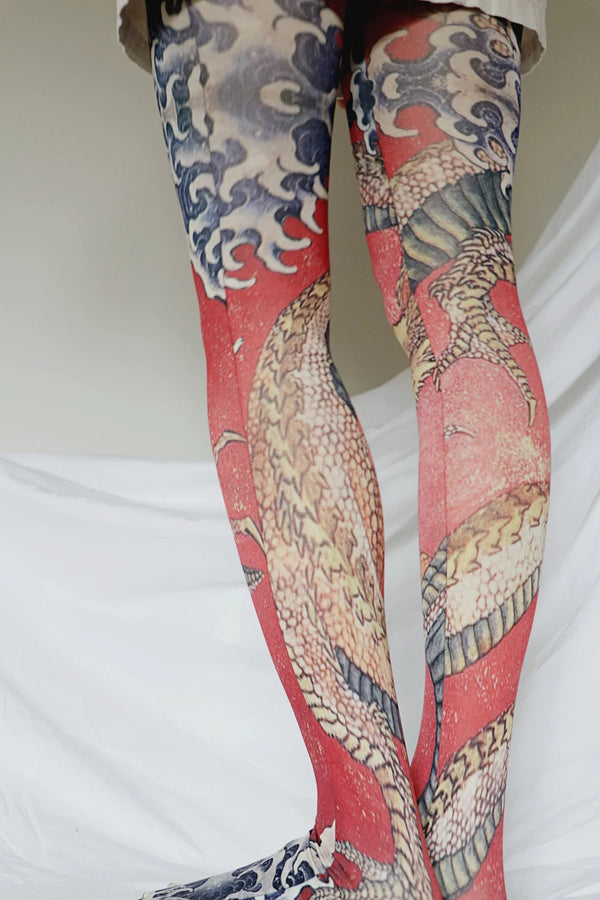 Woman's leg in ivory skirt wearing Tabbisocks Tights-Tabbisocks-Dragon-By-Katsushika-Hokusai-Printed-Art-Tights from oblique view from behind