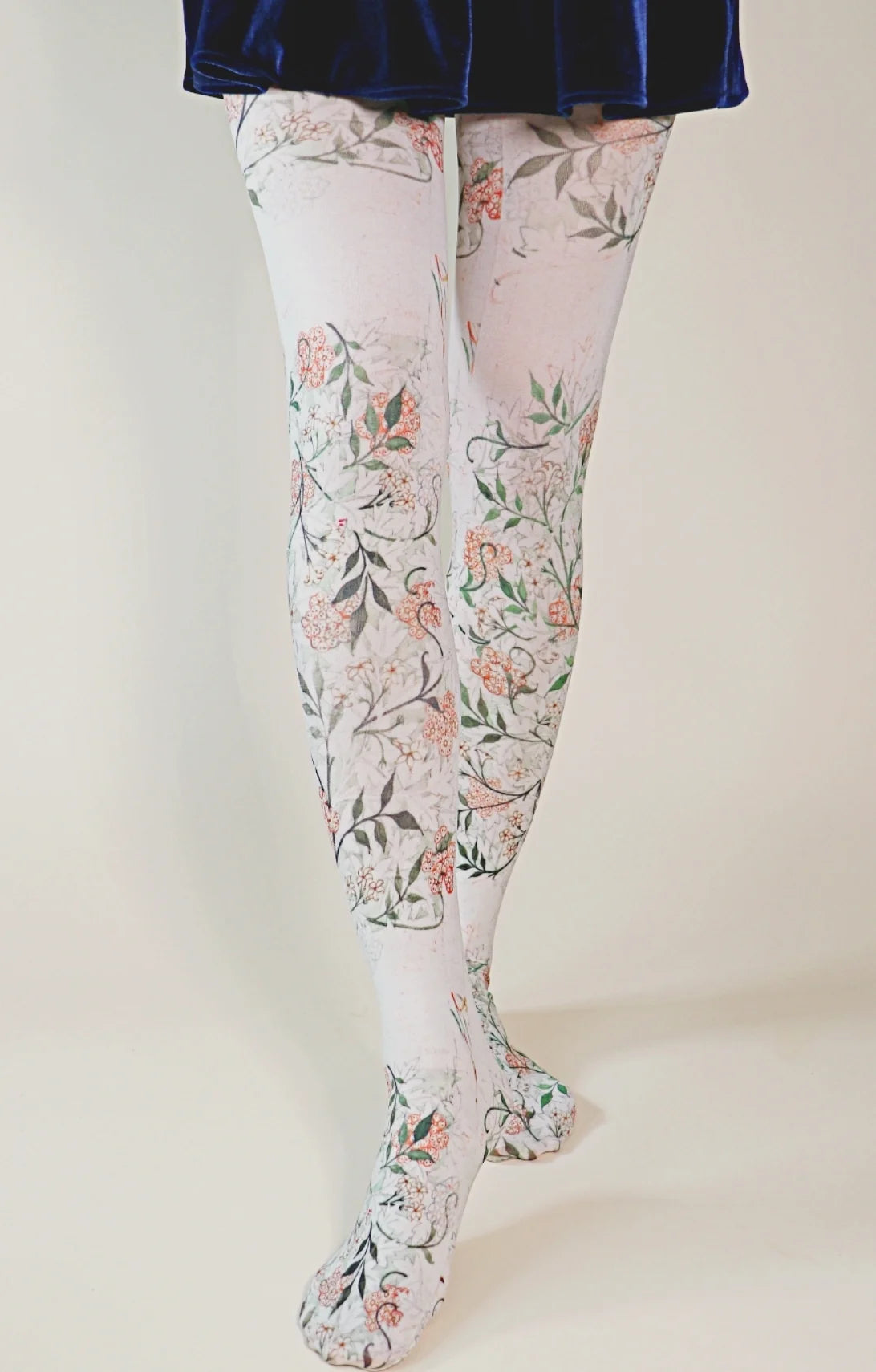 Female leg wearing a velour navy blue skirt with Tabbisocks Jasmine by William Morris Printed Art Tights