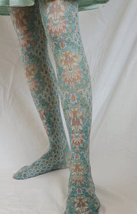 Front view of the lower half of a woman in a pastel green skirt wearing Tabbisocks' Silk Panel by The Metropolitan Museum of Art Printed Art Tights product