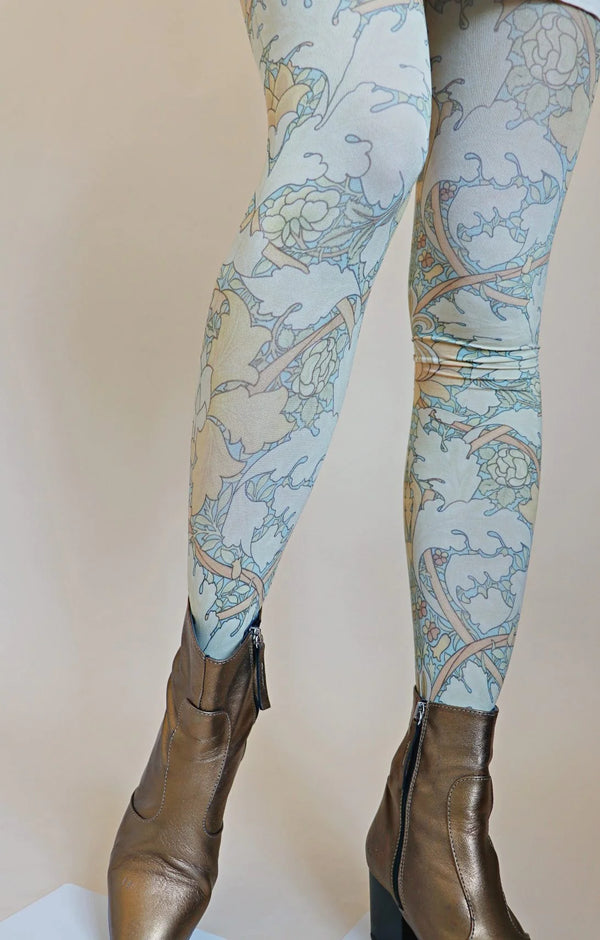 Tabbisocks St Jame's Place By William Morris Printed Art Tights in light blue with a William Morris design on the lower half of a woman's body with gold short boot