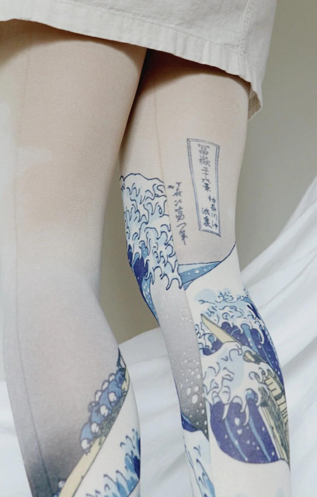 Close-up of a woman's leg in ivory skirt wearing tights called "The Great Wave off Kanagawa by Katsushika Hokusai Printed Art Tights" on Tabbisocks